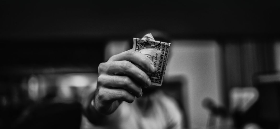 A man holding a dollar bill