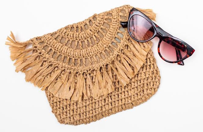 straw clutch and sunglasses