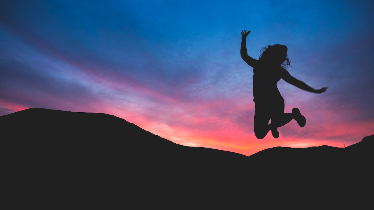 woman jumping in a sunset