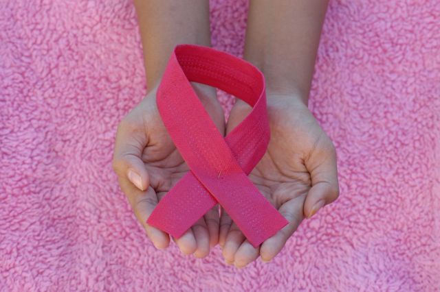 Hands holding pink breast cancer awareness ribbon