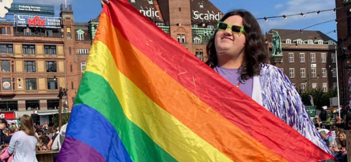 Image of Sylvia Thomas holding the pride flag