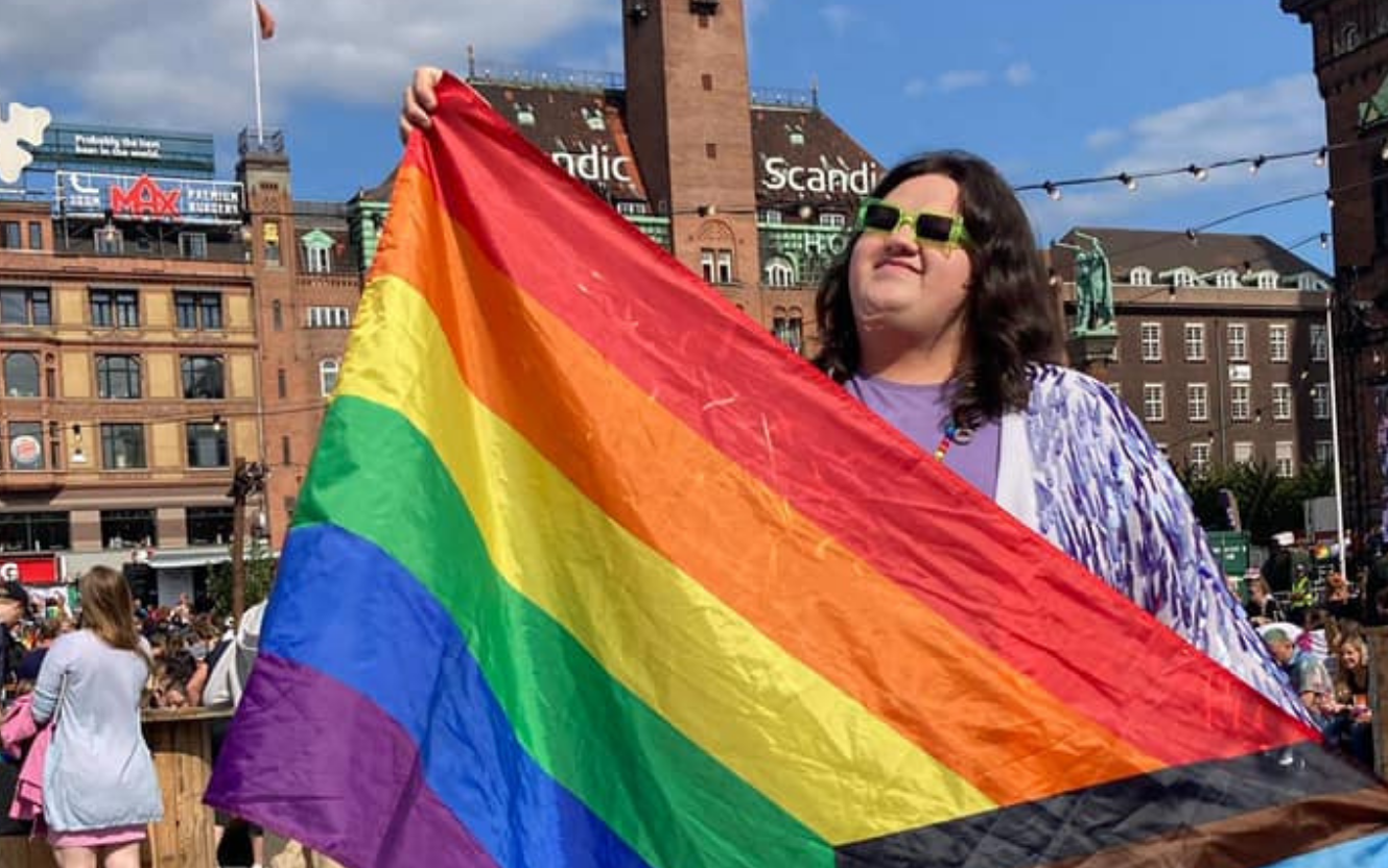 Image of Sylvia Thomas holding the pride flag
