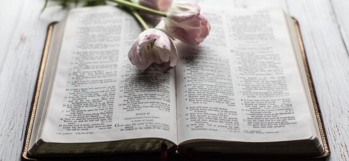 Bible with pink flowers laying on top