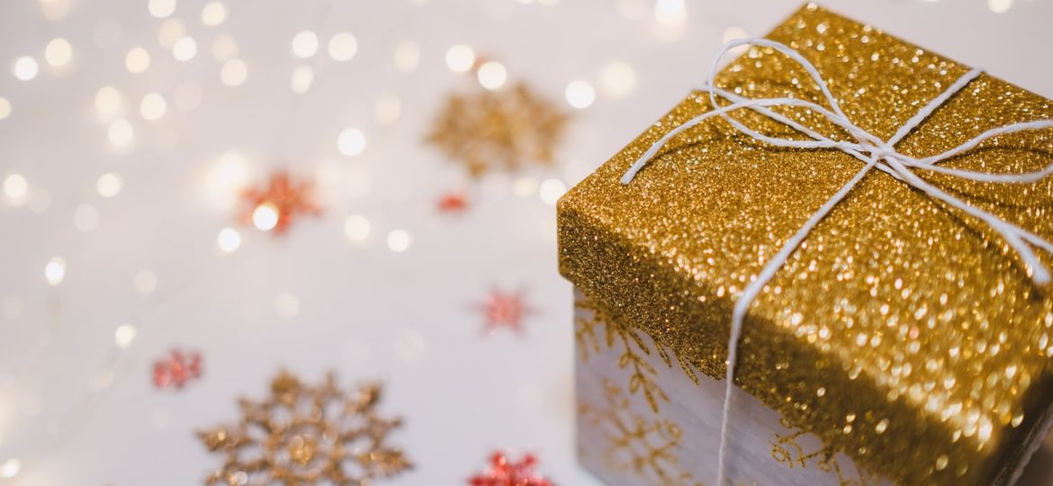 A gold package on a white background with colored snowflakes