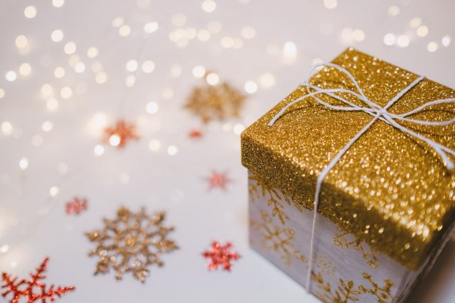 A gold package on a white background with colored snowflakes