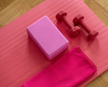 A photo of a yoga mat with a towel and hand weights