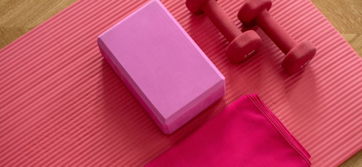 A photo of a yoga mat with a towel and hand weights