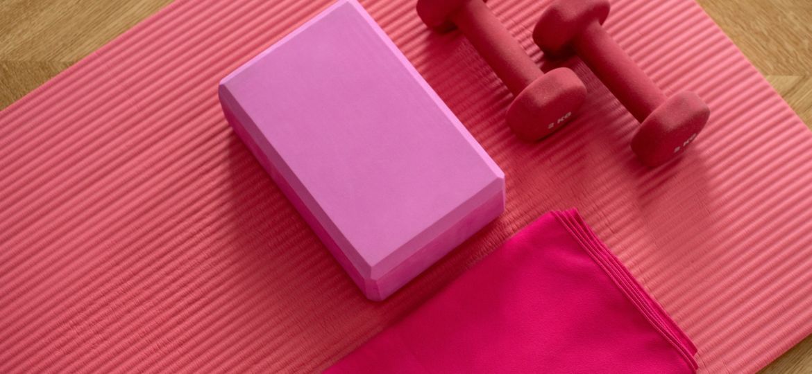 A photo of a yoga mat with a towel and hand weights