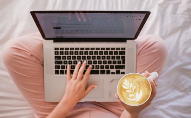 A woman with a latte and a laptop