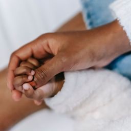 A mom holding a baby's hand