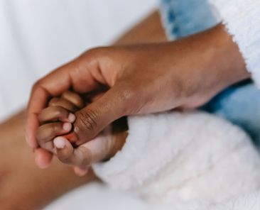 A mom holding a baby's hand