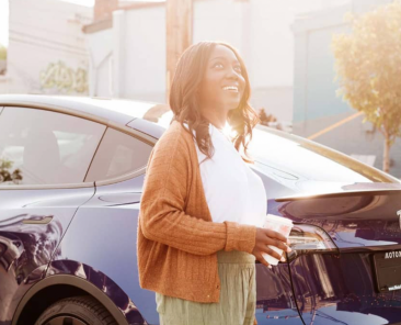 A woman standing in front of a car
