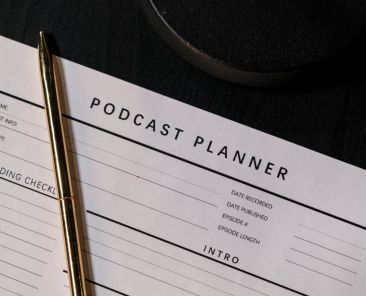 A photo of a podcast planner with a pen