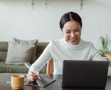 A smiling woman working on a laptop