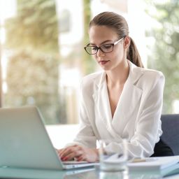 A photo of a woman looking at a laptop