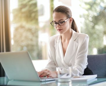 A photo of a woman looking at a laptop
