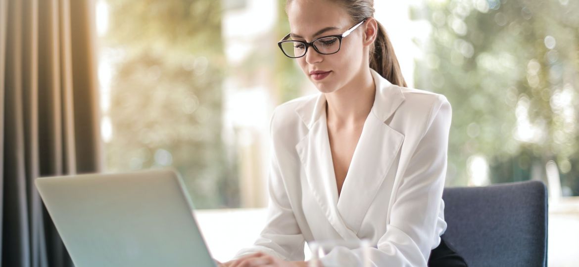 A photo of a woman looking at a laptop