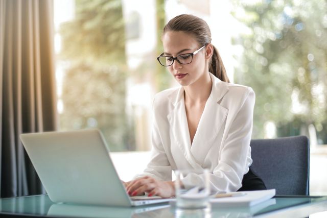 A photo of a woman looking at a laptop