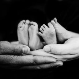 A photo of hands holding baby feet