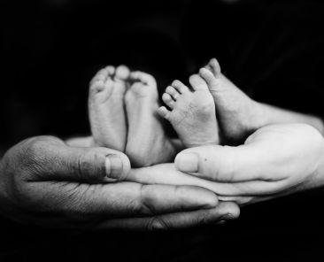 A photo of hands holding baby feet