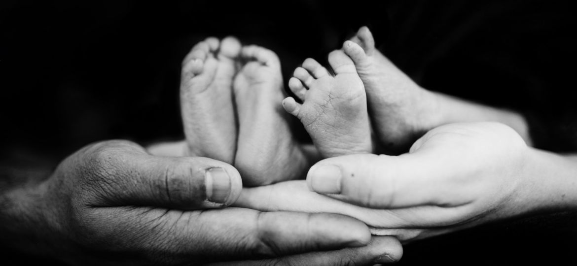A photo of hands holding baby feet
