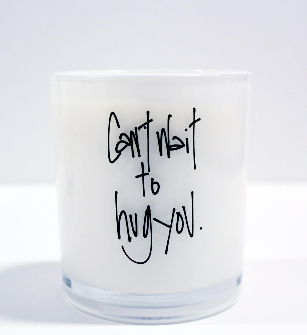 Candle that says "can't wait to hug you."