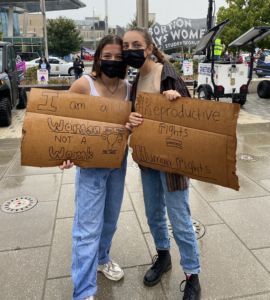 A photo of Sydney and Lisa holding signs about consent