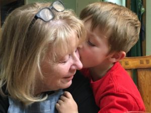 A photo of Nan and her grandson giving a kiss on the cheek