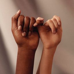 Two women linking fingers