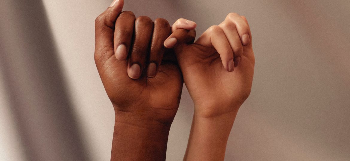 Two women linking fingers