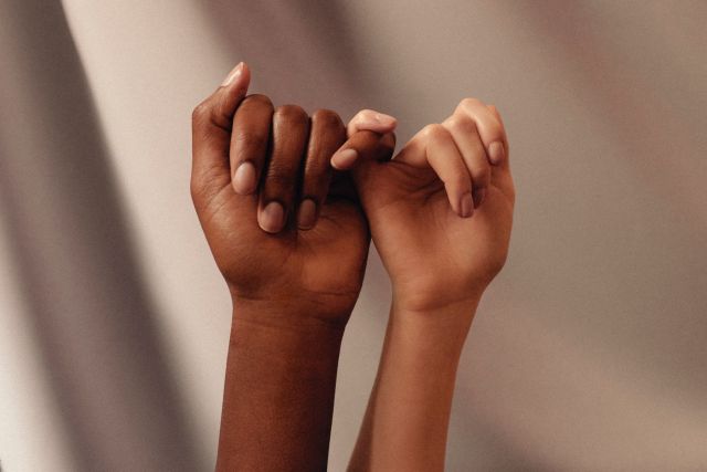 Two women linking fingers