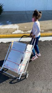 A photo of Amor holding a rolling cart with packages