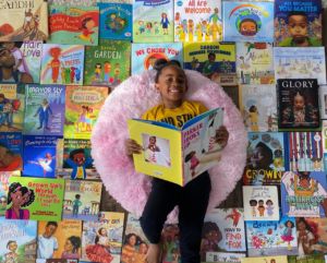 A photo of Amor laying with children's books surrounding her