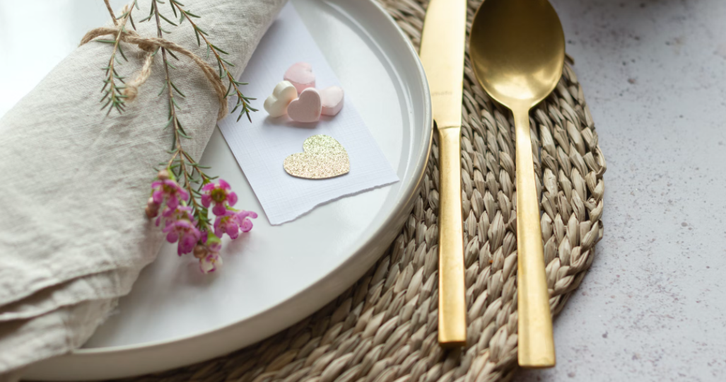 A photo of a plate with hearts and flowers on it next to silverware