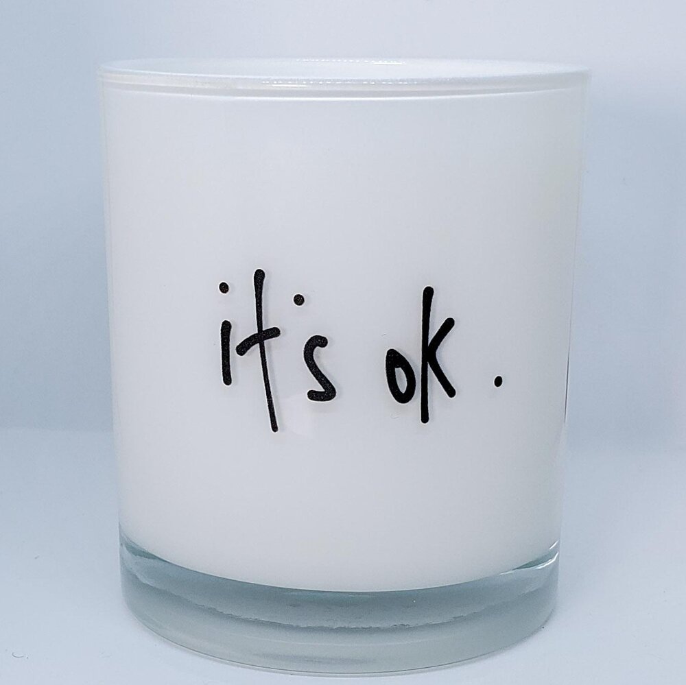 Candle with writing that says "it's ok."