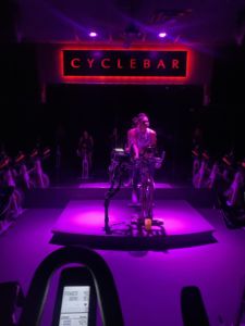 A photo of a purple lit room with a Cyclebar sign