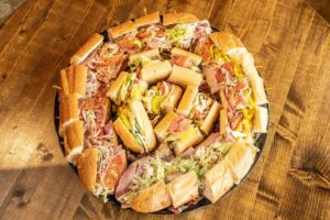 A photo of a party platter of hoagies