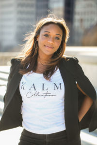 A photo of Kai Johnson smiling with a KALM t-shirt on