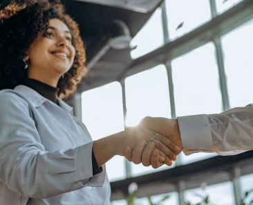 A photo of a woman shaking someone's hand