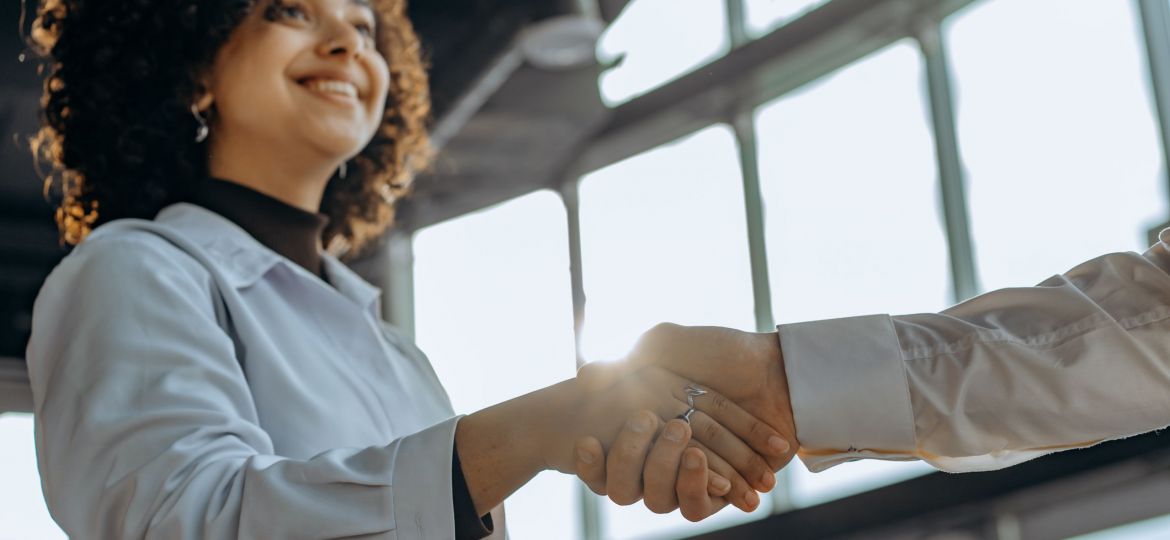 A photo of a woman shaking someone's hand