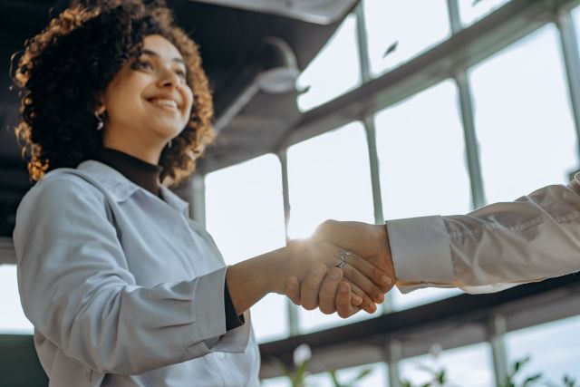 A photo of a woman shaking someone's hand