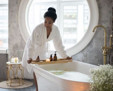 A woman leaning over a bathtub