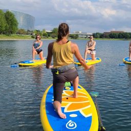 A woman teaching a paddle board yoga class