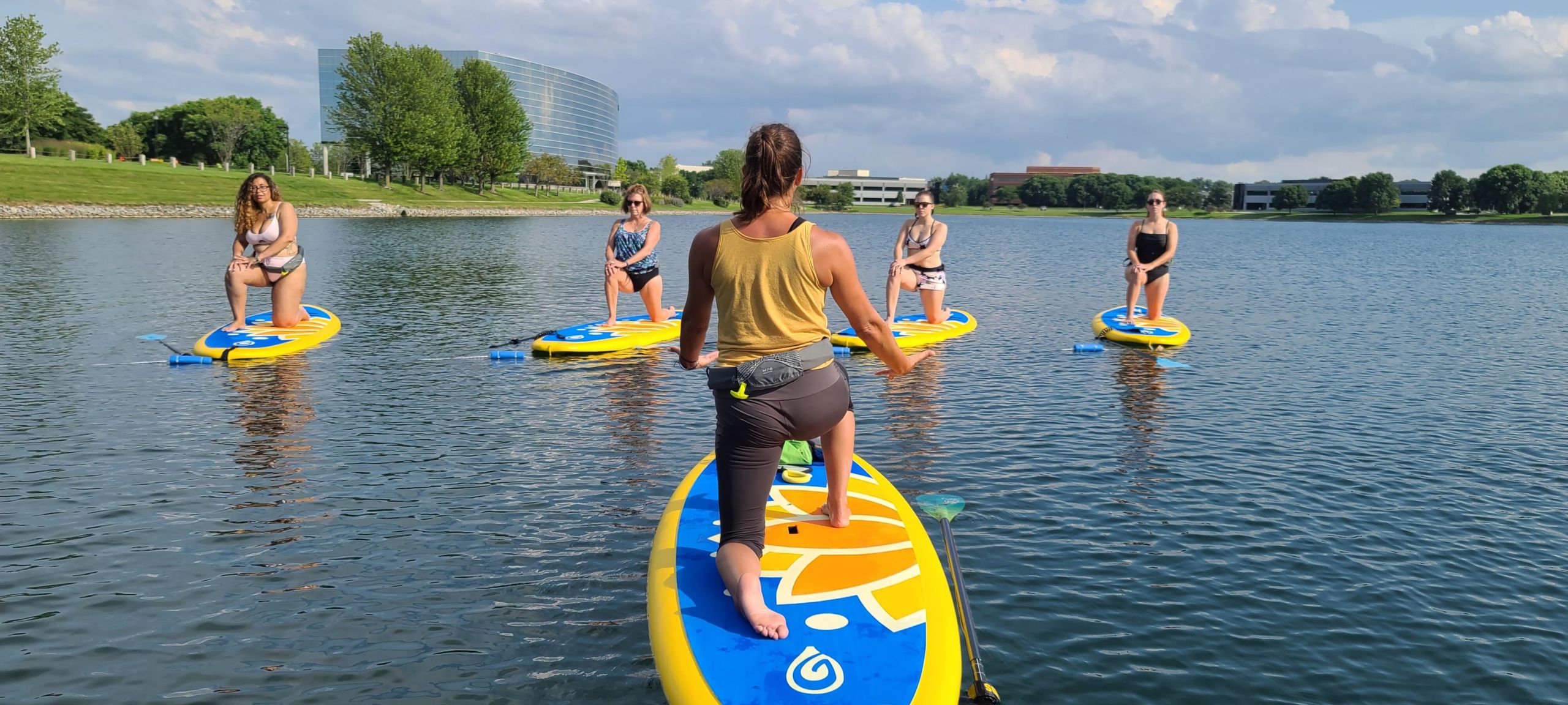 A woman teaching a paddle board yoga class