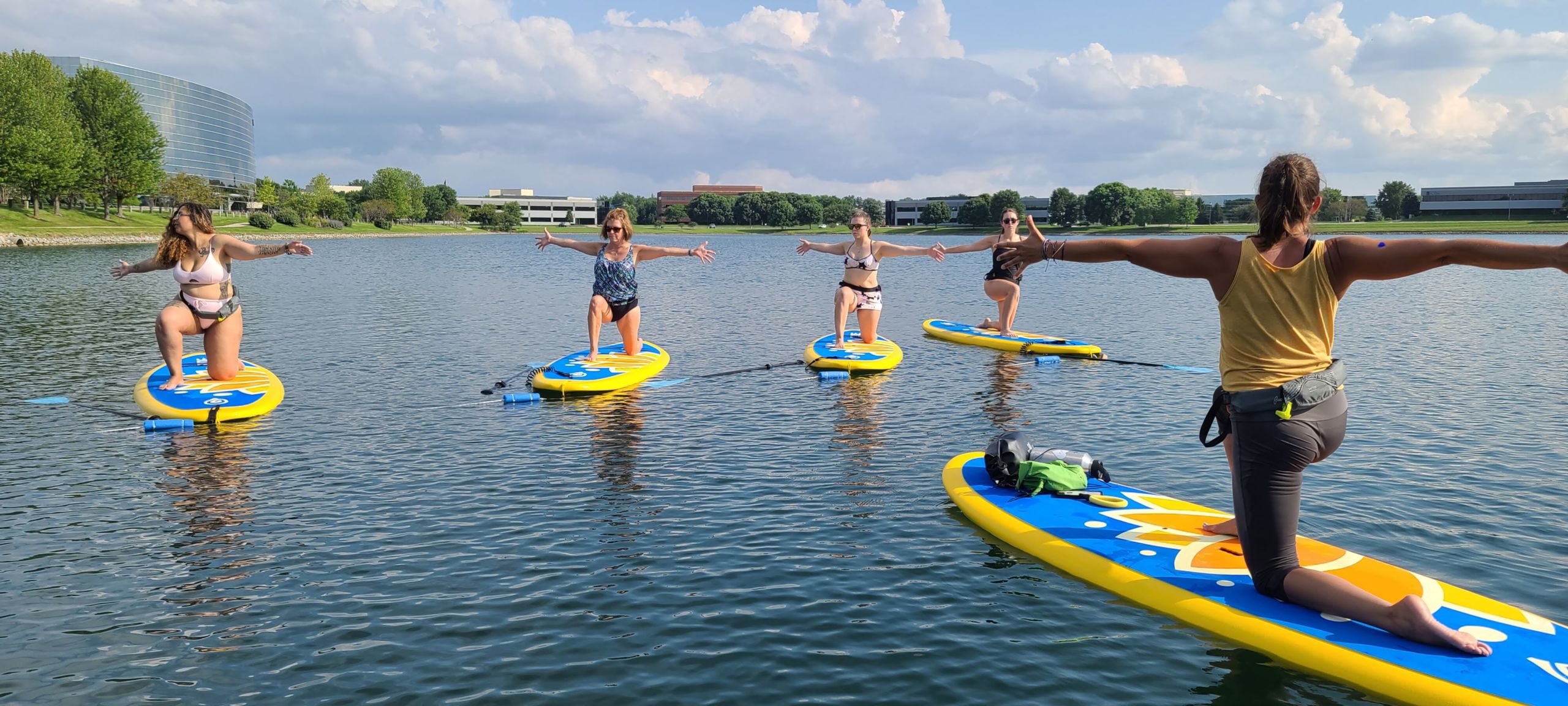 A woman teaching a paddle board yoga class