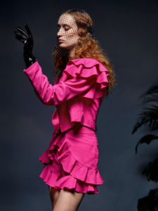A SHEIN X Redefinition model in a pink dress with ruffles and black gloves