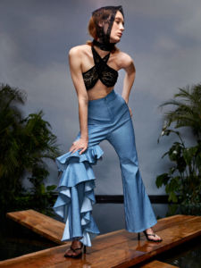 A SHEIN X Redefinition model in blue pants with ruffles and a black halter top