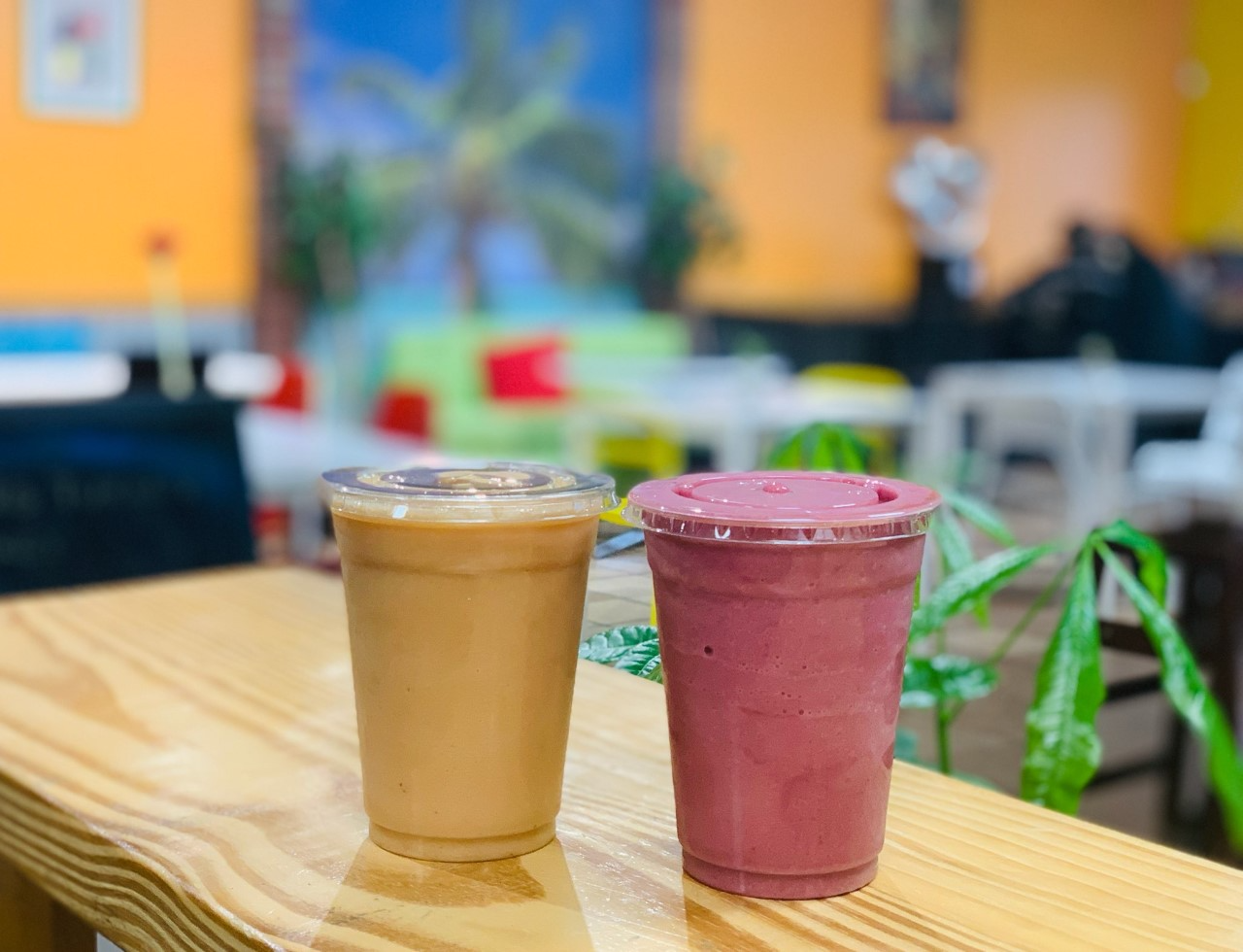 A photo of a pink smoothie next to a yellow smoothie