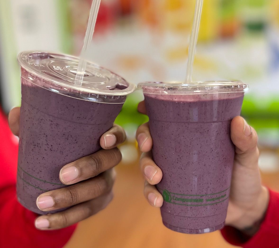 A photo of two purple smoothies doing a cheers