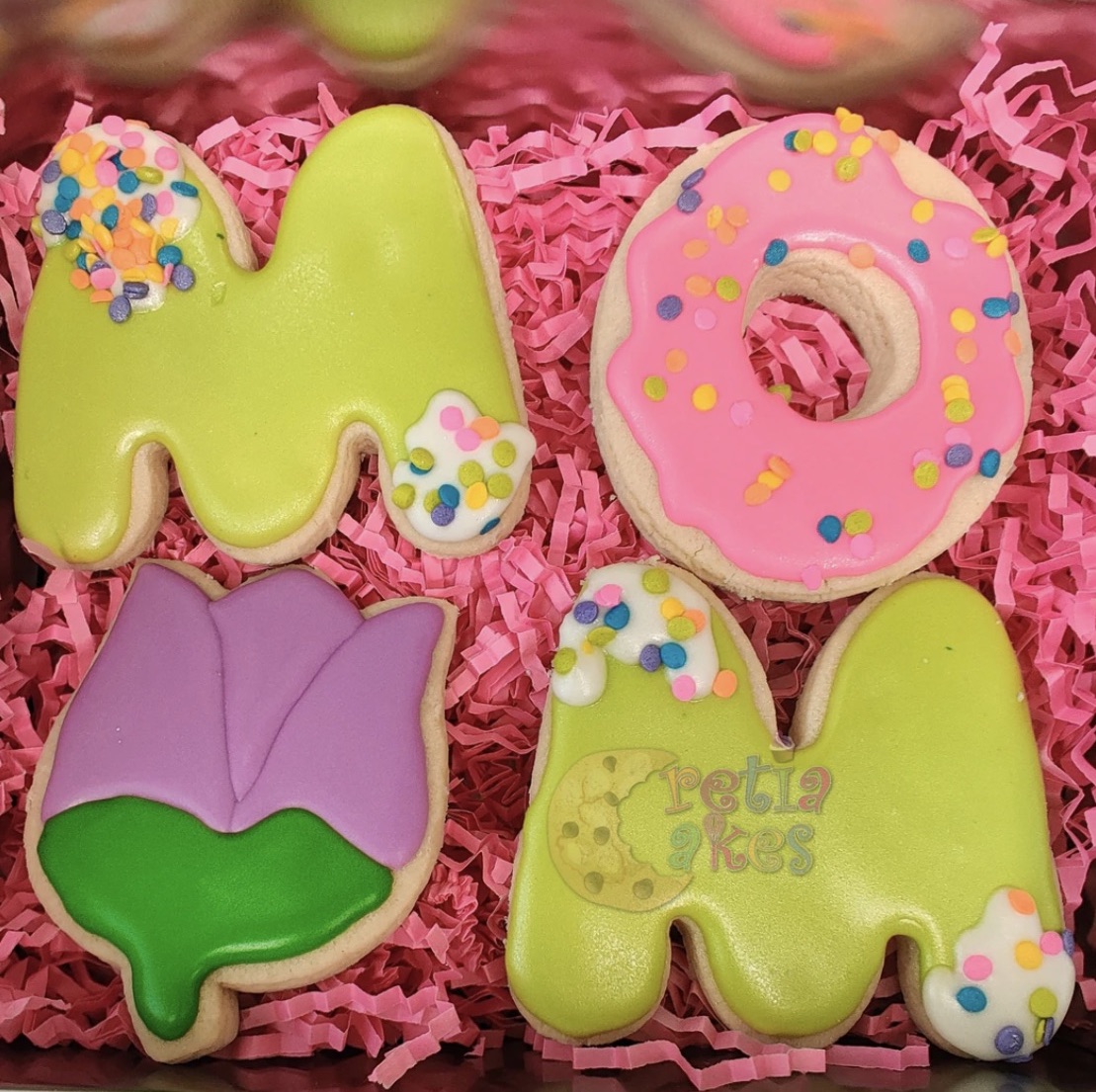 A photo of cookies that spell MOM and are decorated with colorful frosting